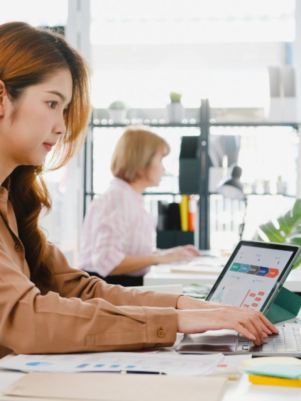 young-asia-businesswoman-entrepreneur-social-distancing-new-normal-situation-virus-prevention-while-using-laptop-computer-tablet-back-work-office